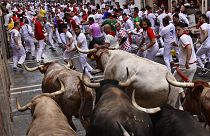 Carreras por las calles con toros y novillos de lidia durante el primer día de los encierros de las fiestas de San Fermín en Pamplona, norte de España, el 7 de julio de 2022