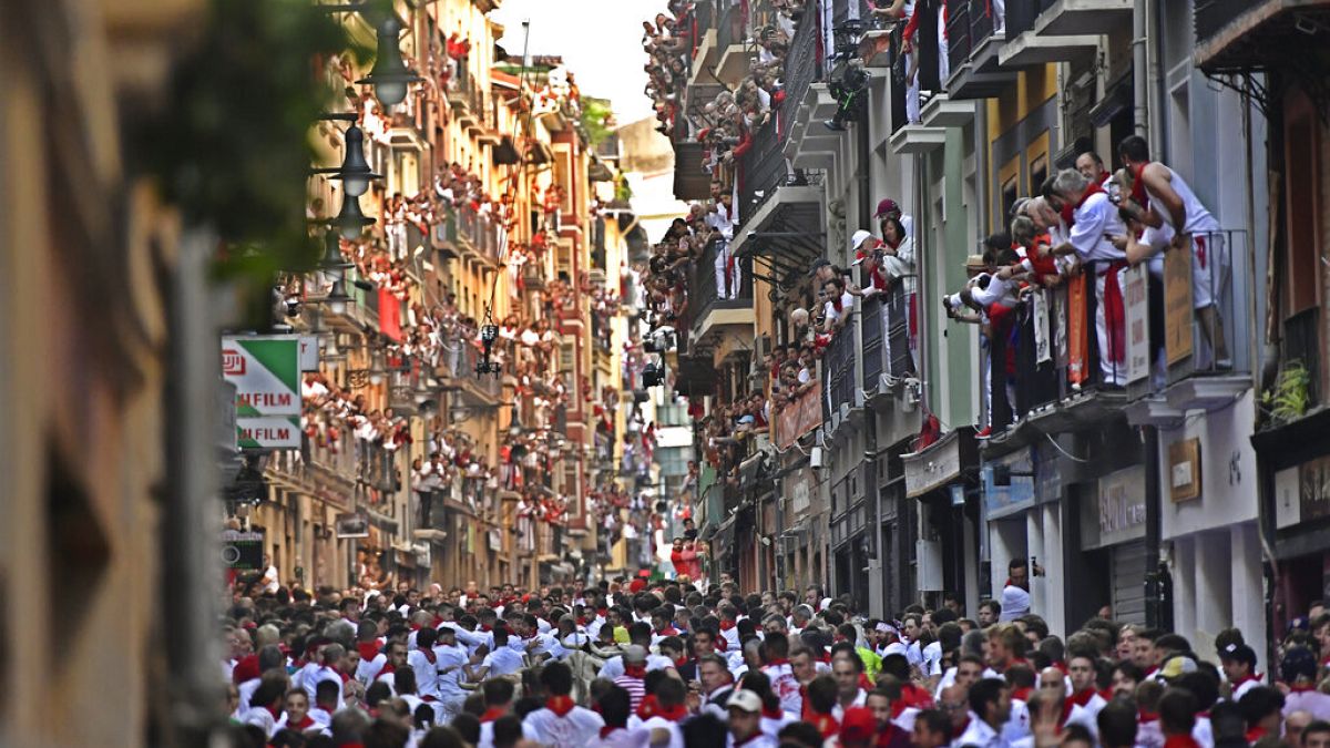 Des gens courent dans les rues devant des taureaux aux fêtes de San Fermin, à Pampelune, dans le nord de l'Espagne, le 7 juillet 2022.