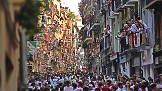Des gens courent dans les rues devant des taureaux aux fêtes de San Fermin, à Pampelune, dans le nord de l'Espagne, le 7 juillet 2022.