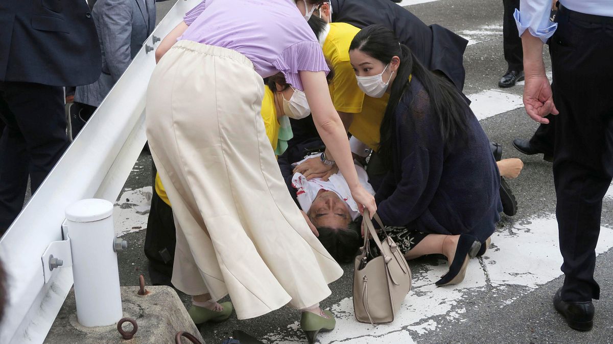 Shinzo Abe ferido no chão e rodeado de pessoas em Nara, Japão