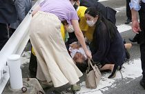 Shinzo Abe ferido no chão e rodeado de pessoas em Nara, Japão