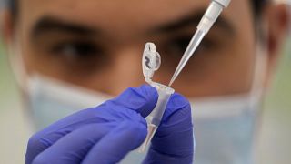 Un asistente de investigación muestra cómo preparar una muestra para la secuenciación en el Instituto Wellcome Sanger de Inglaterra, 2022.
