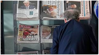 مواطن ينظر إلى الصفحات الأولى للصحف المعروضة في لندن، 8 يوليو ، 2022.
