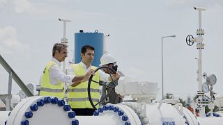 رئيس الوزراء اليوناني كيرياكوس ميتسوتاكيس، إلى اليسار، ونظيره البلغاري كيريل بيتكوف، يديران الصمام أثناء افتتاح خط أنابيب الغاز في كوموتيني، اليونان، 8 يوليو. 