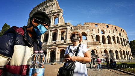 Tourists wear masks on a visit to Rome.
