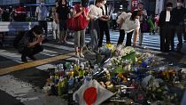 Жители города Нара на юге Японии возлагают цветы на месте убийства Синдзо Абэ, 8 июля 2022 года