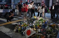 Жители города Нара на юге Японии возлагают цветы на месте убийства Синдзо Абэ, 8 июля 2022 года
