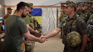 Ukrainian President Volodymyr Zelenskyy, left, awards a serviceman as he visits the war-hit Dnipropetrovsk region on 8 July 2022