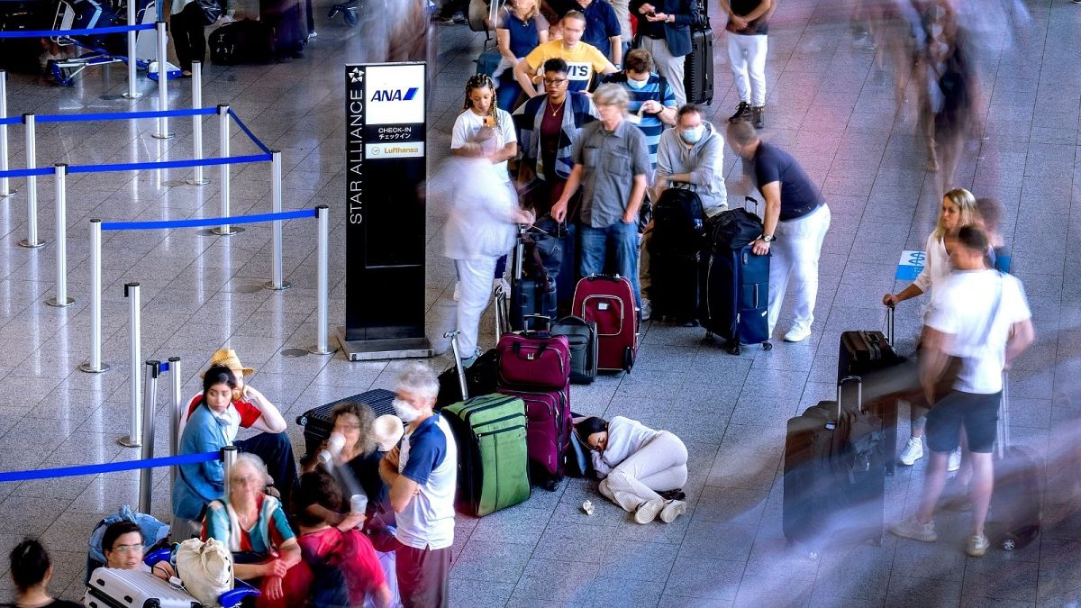A woman rests in a queue at a check-in terminal at Frankfurt international airport on 2 July.