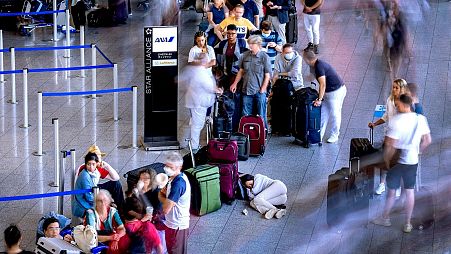 A woman rests in a queue at a check-in terminal at Frankfurt international airport on 2 July.