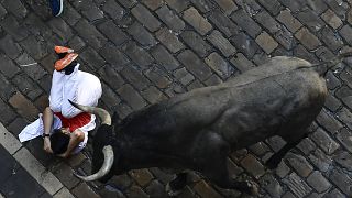 Ein Läufer stürzt bei der Stierhatz durch Pamplona am Samstag.