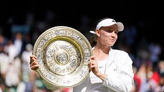 Kazakhstan's Elena Rybakina holds the trophy after winning the final of the women's tennis singles against Tunisia's Ons Jabeur at Wimbledon, July 9, 2022.