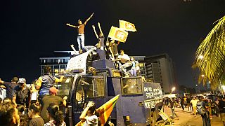Demonstrierende stehen auf einem zerstörten Wasserwerfer der Polizei am Eingang des Amtssitzes des Präsidenten in Colombo, Sri Lanka