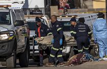 Un corps est retiré de la scène de la fusillade survenue dans un bar à Soweto, en Afrique du Sud, dimanche 10 juillet 2022.