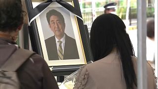 A volt japán miniszterelnök emléke előtt tisztelgő emberek Narában. 