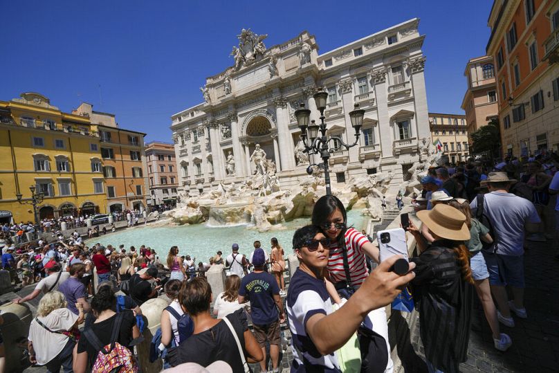 گردشگران در مقابل فواره تروی در رم، پایتخت ایتالیا، سلفی می گیرند