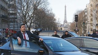 A chauffeur stands by his vehicle during demonstration in Paris, Wednesday, Feb. 3, 2016.
