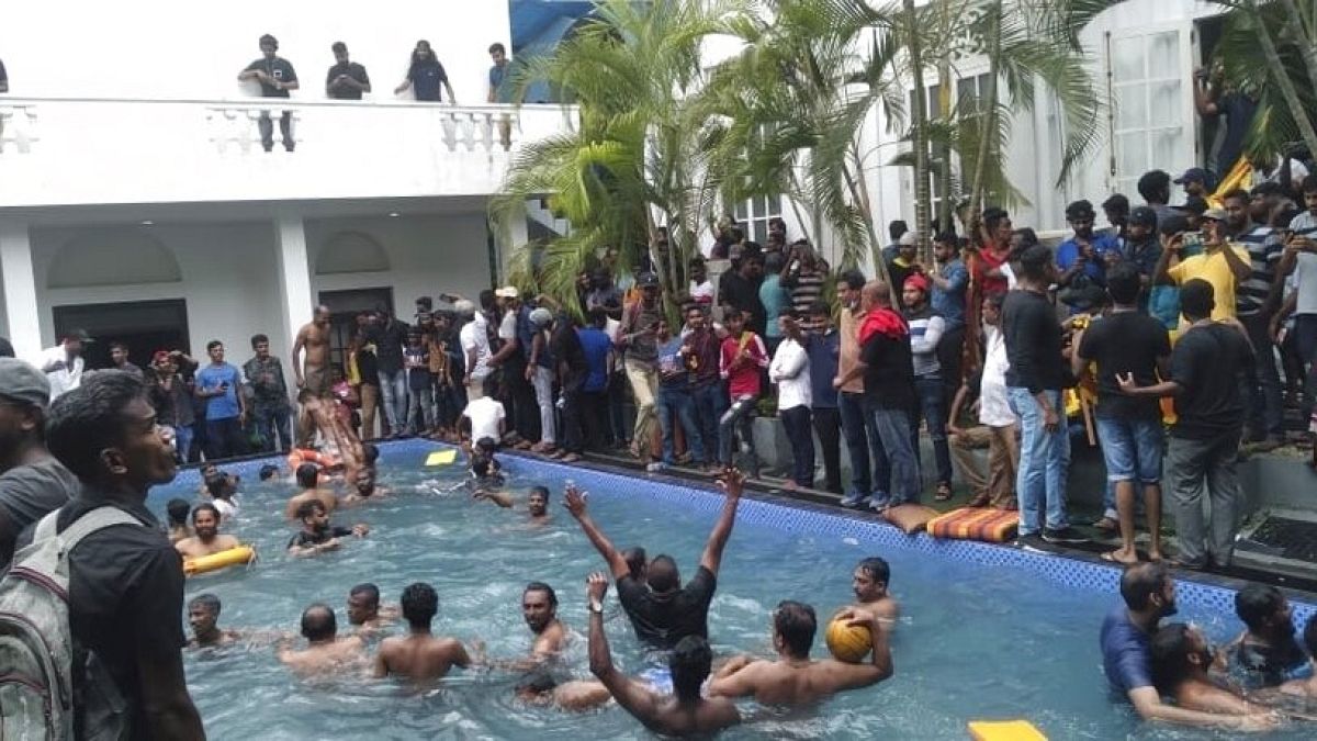 Anti government protesters swim in a swimmingpool of the Sri lankan president's official residence after storming into it in Colombo, Sri Lanka, Saturday, July 9, 2022.