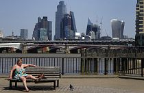 Eine Frau sonnt sich an der Themse in London.