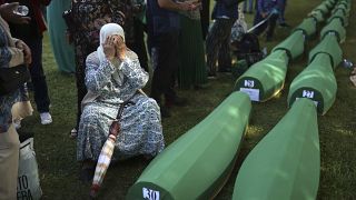 Боснийская женщина оплакивает своего мужа, тело которого собираются захоронить. 11 июля 2022