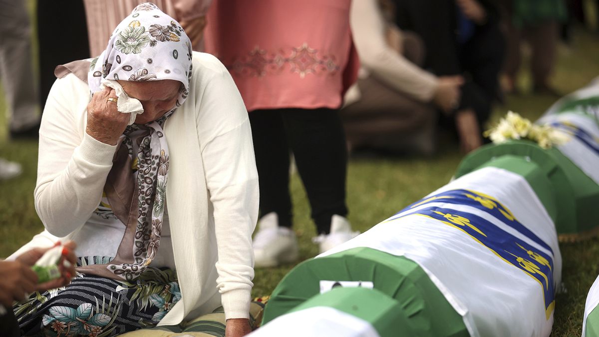 A Bosniak woman mourns next to the remains of a family member who is amongst the 50 newly identified victims of the Srebrenica Genocide, in Potočari, 11 July 2022