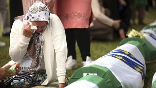A Bosniak woman mourns next to the remains of a family member who is amongst the 50 newly identified victims of the Srebrenica Genocide, in Potočari, 11 July 2022
