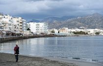 A woman walks on the beach of Ierapetra on the southeast coast of the Greek island of Crete.