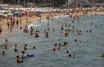 La gente se refresca en el agua durante el clima cálido en una playa de Barcelona, España, el domingo 19 de junio de 2022