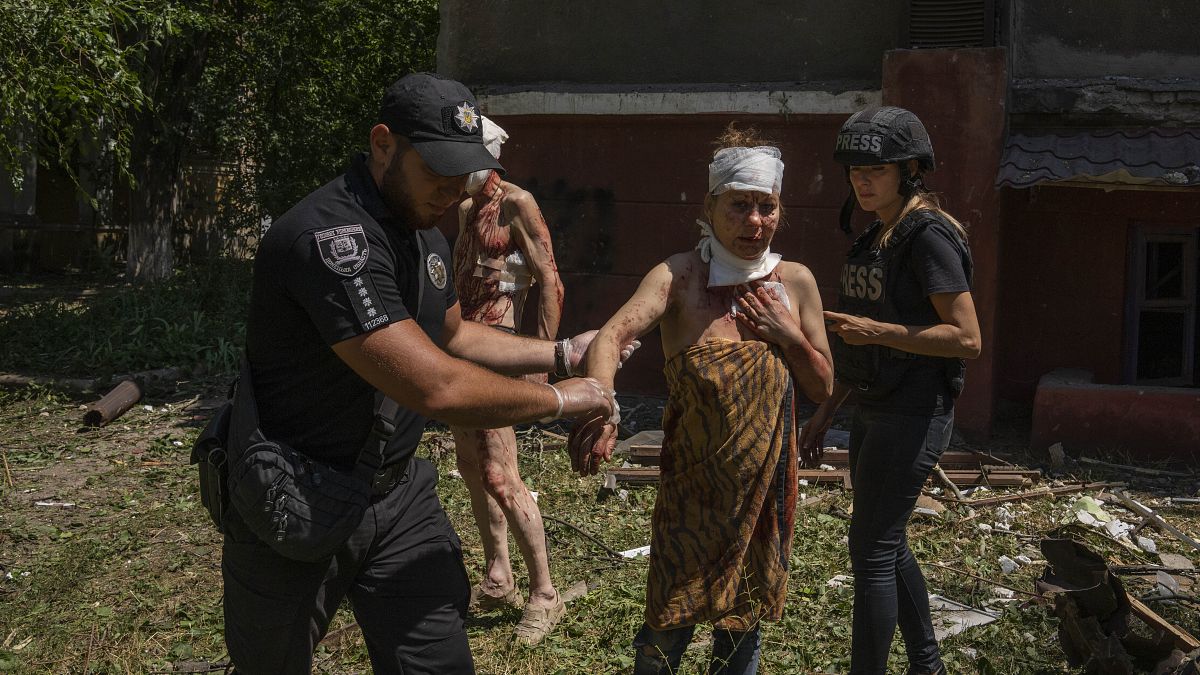 Un policier aide une femme blessée après la frappe d'un missile sur une zone résidentielle à Kramatorsk, dans la région de Donetsk (Ukraine), jeudi 7 juillet 2022.
