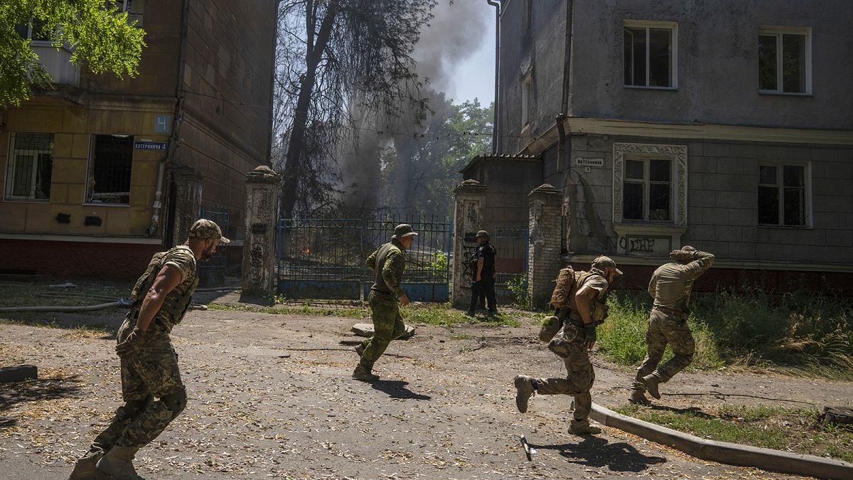 Ukrainian soldiers run after a missile strike hit a residential area in Kramatorsk, 7 July 2022