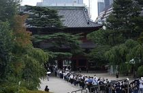 حشودٌ تصطف في طابور للدخول إلى معبد "زويويجي" لإلقاء نظرة الوداع على جثمان رئيس الوزراء الياباني السابق شينزو آبي، قبل انطلاق موكب تشييعه في طوكيو، 12 يوليو 2022. 