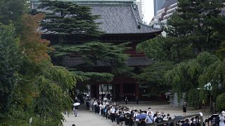 حشودٌ تصطف في طابور للدخول إلى معبد "زويويجي" لإلقاء نظرة الوداع على جثمان رئيس الوزراء الياباني السابق شينزو آبي، قبل انطلاق موكب تشييعه في طوكيو، 12 يوليو 2022. 