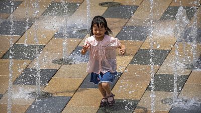 Egy kislány egy kínai bevásárlóközpont szökőkútjában játszik