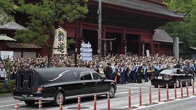 The vehicle, left, carrying the body of former Japanese Prime Minister Shinzo Abe.