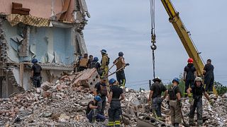 Rescue workers sift through rubble in the aftermath of a Russian rocket that hit a residential building in Chasiv Yar, Donetsk region, eastern Ukraine, July 10, 2022.
