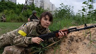 A woman holds a riffle as she attends a combat medic course training in Kyiv, Ukraine, Monday, July 11, 2022.