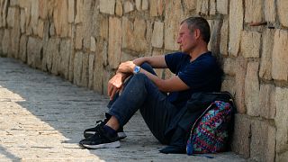 Un homme est assis à l'ombre derrière un mur pendant la canicule à Madrid, en Espagne, mercredi 13 juillet 2022.