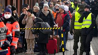 Displaced Ukrainians stand in a line on the train platform after arriving from Ukraine at the station in Przemysl, Poland, Thursday, March 3, 2022.