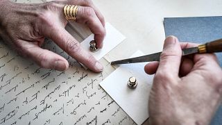 Une employée travaille sur un feuillet d'un manuscrit original de l'écrivain français Marcel Proust, pendant sa rénovation à la "BnF" à Paris, le 8 juillet 2022s, l