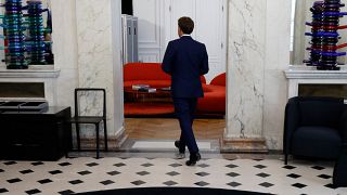 French President Emmanuel Macron exits a lobby in the presidential Elysee Palace, in Paris, on June 21, 2022,