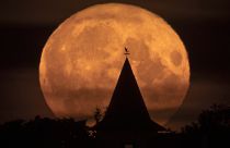 The full moon rises over a private house in the village of Putilovo, 70 kilometeres (43 miles) east of St. Petersburg, Russia, late Wednesday, July 13, 2022.