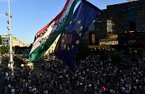 A flag reads "democracy, rule of law, republic" as demonstrators in Budapest protest against a tax overhaul on Wednesday, July 13, 2022.