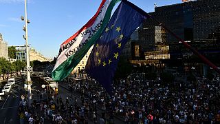 A flag reads "democracy, rule of law, republic" as demonstrators in Budapest protest against a tax overhaul on Wednesday, July 13, 2022.
