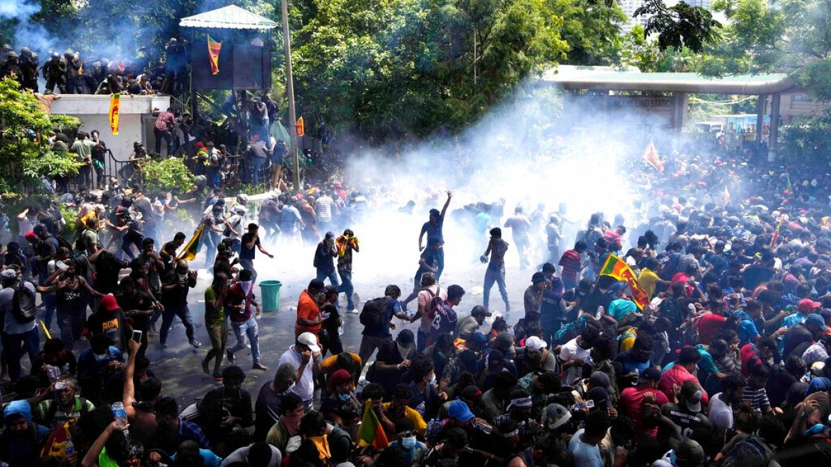 Police use tear gas to disperse protesters who stormed the compound of prime minister Ranil Wickremesinghe's office, Colombo, Sri Lanka, Wednesday, July 13, 2022. 