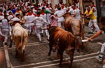 People run through the streets with fighting bulls during the last day of the running of the bulls at the San Fermin festival in Pamplona, Spain, Thursday, July 14, 2022