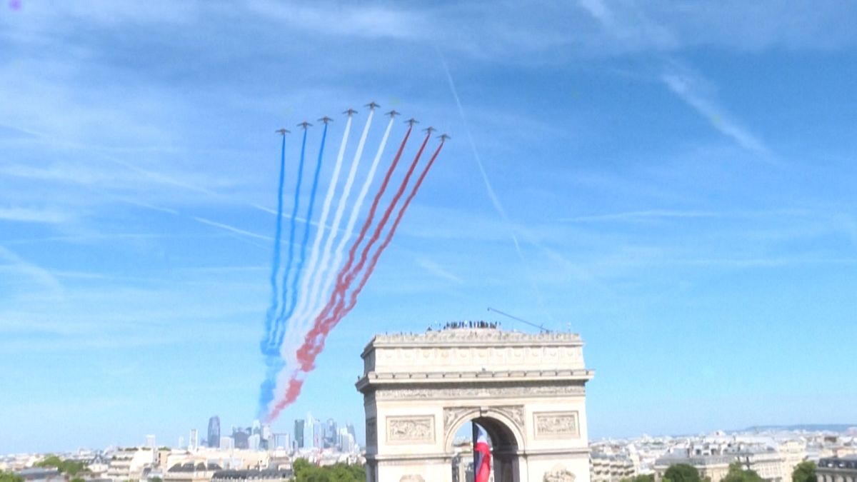  The Patrouille de France (France's fighter jet squadron, Eds.) leaving clouds of blue, white and red smoke flying over La Defense towards the Champs-Elysees.