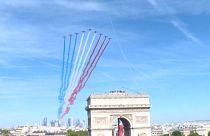   The Patrouille de France (France's fighter jet squadron, Eds.) leaving clouds of blue, white and red smoke flying over La Defense towards the Champs-Elysees.