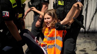 Police officers carry away climate activist Lina Schinkoethe during a protest with the group Uprising of the Last Generation at the chancellery in Berlin, Germany,.