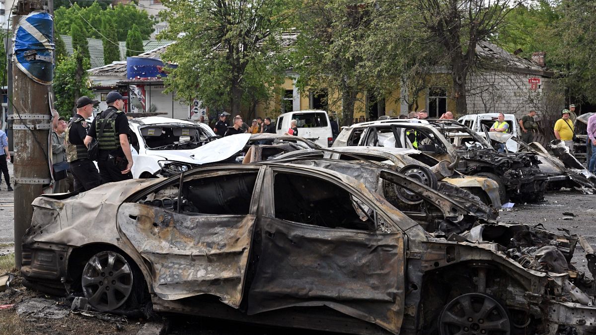أفراد من الشرطة بجانب سيارات متفحمة في أعقاب غارة جوية روسية في مدينة فينيتسا 14/07/2022