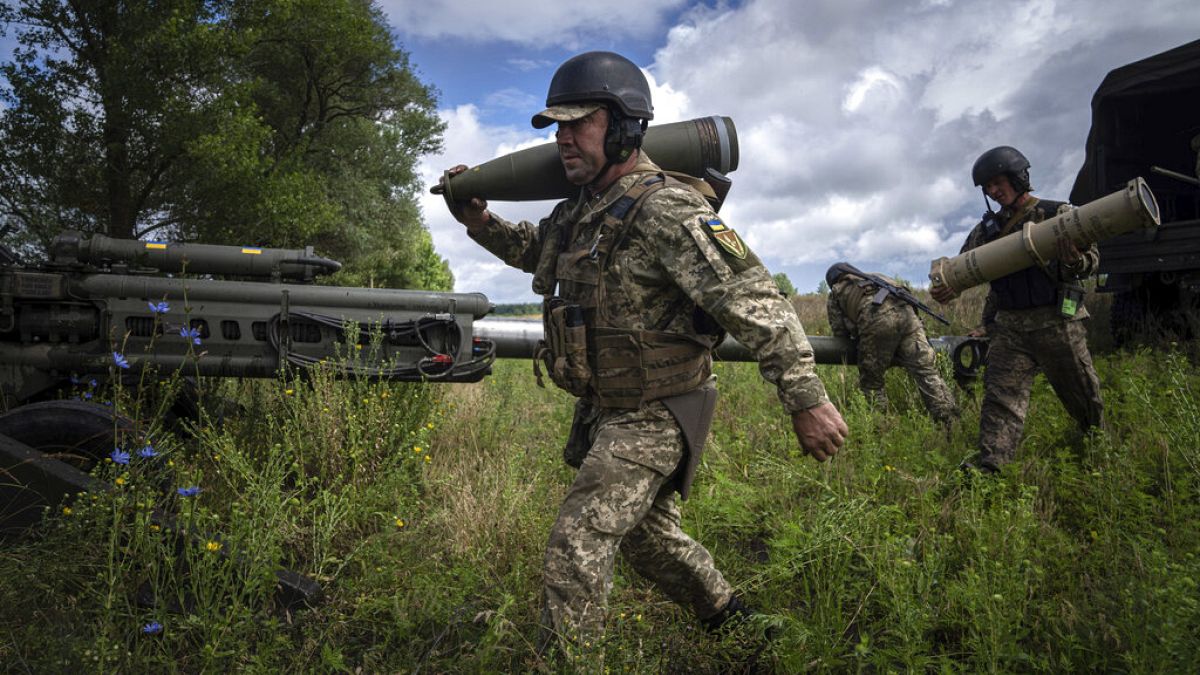 جندي أوكراني يحمل قذيفة مدفعية عيار 155 ملم قبل إطلاق النار على مواقع روسية من مدفع هاوتزر M777 قدمته الولايات المتحدة في منطقة خاركيف، أوكرانيا، الخميس 14 يوليو 2022